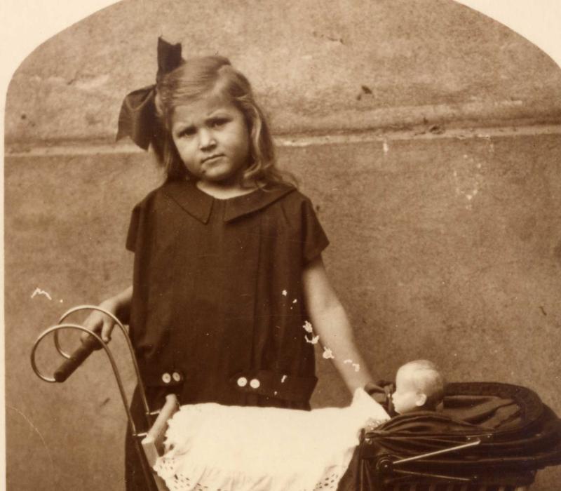 Altes Foto eines Mädchens mit einem Puppenwagen